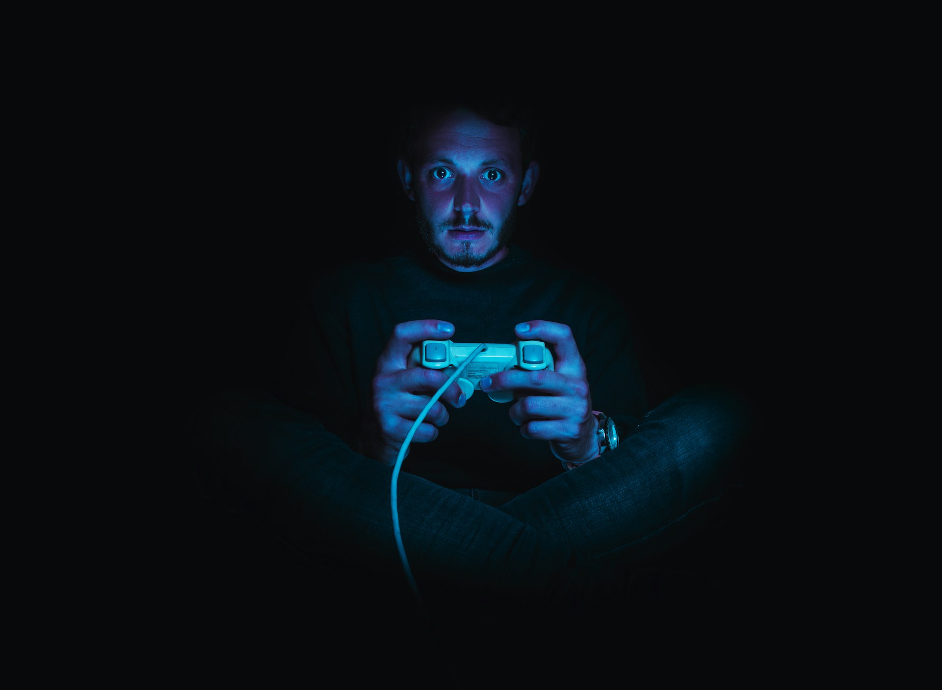 a man sitting in the dark holding a console controller to depict the immersiveness of RPG style type games Image source: https://unsplash.com/photos/man-holding-corded-game-controller-TPH3q6202qA