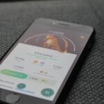 a mobile phone on a couch with Pokemon Go running on it to represent the preparation for some of the Pokemon events in 2025 Image source: https://www.pexels.com/photo/turned-on-iphone-displaying-pokemon-go-charizard-application-243698/