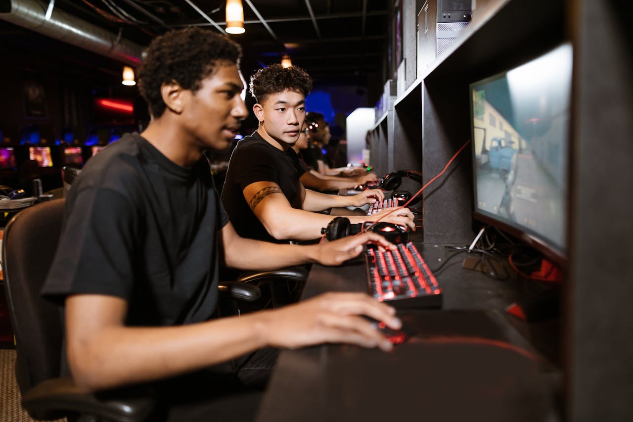 Men playing a video game, one of the top FPS games of 2024, in a gaming cafe