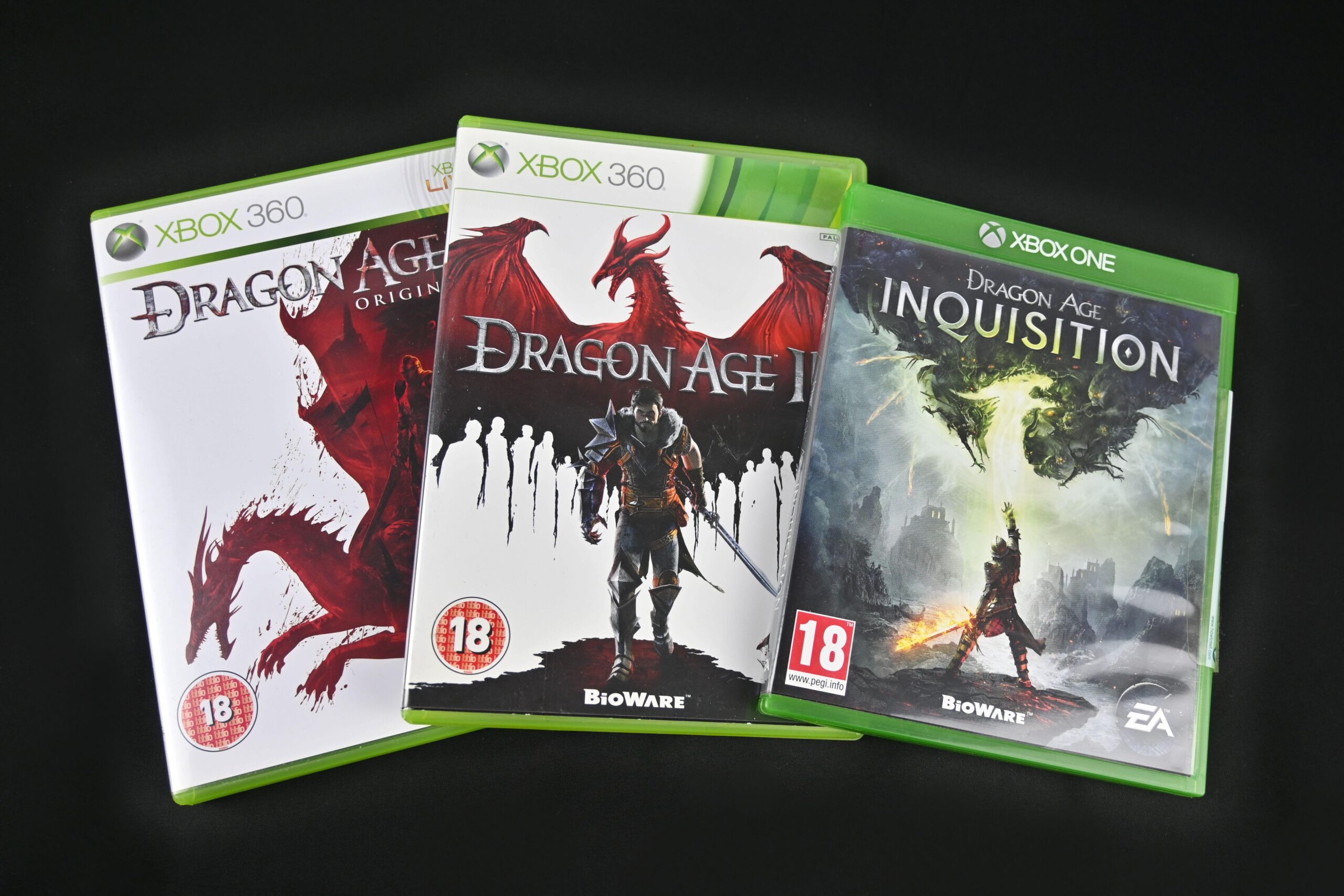 Three X Box disks of Dragon age to represent the RPG remakes and sequels