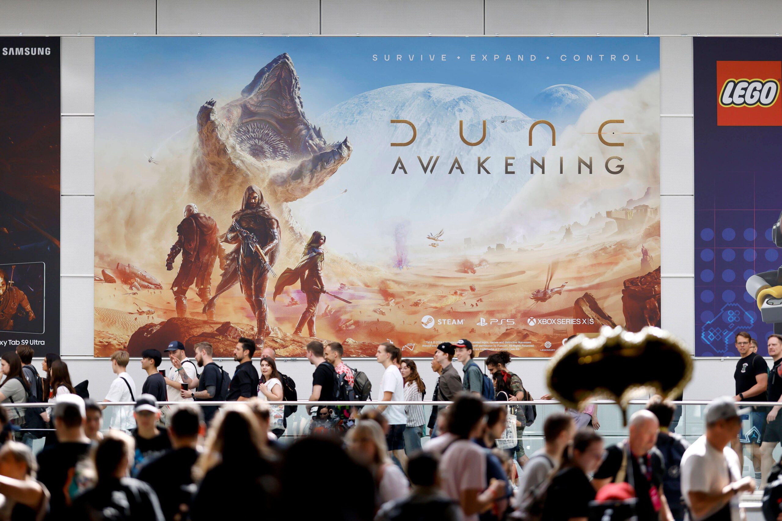 A promotional poster of Dune: Awakening in a gaming convention